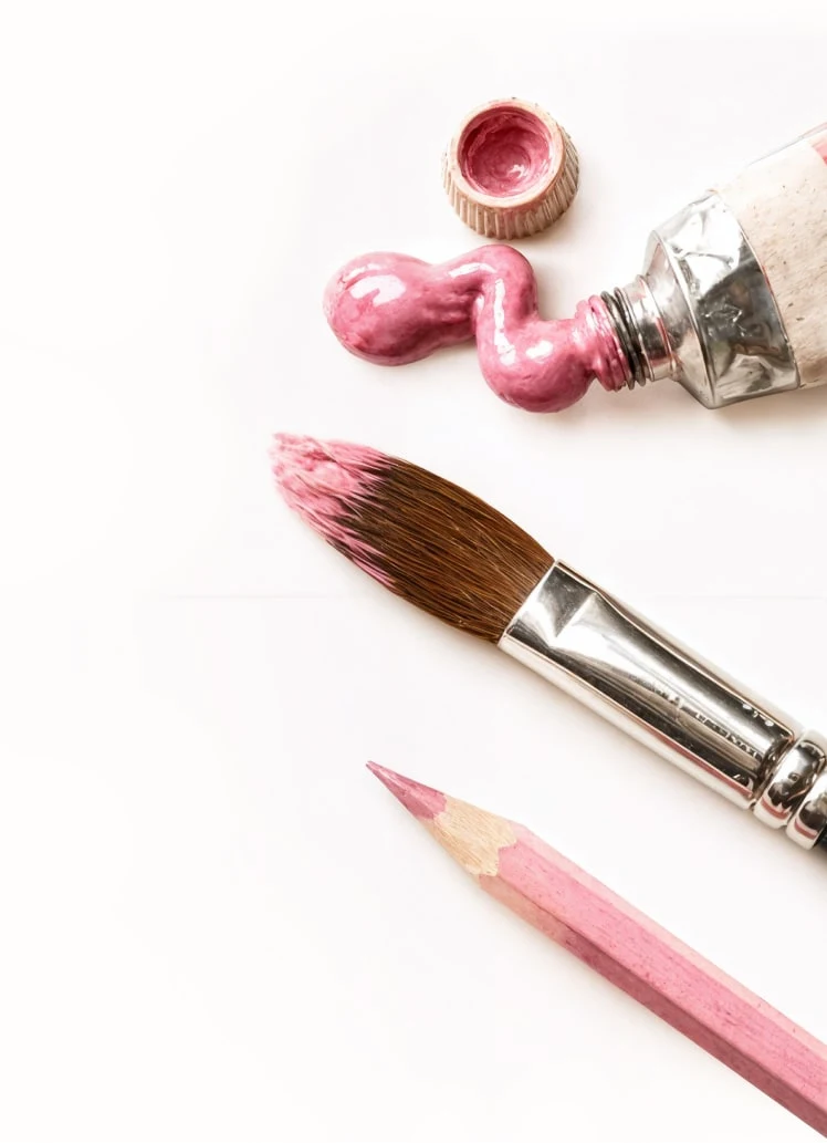 Paintbrushes, pink paint and a pencil